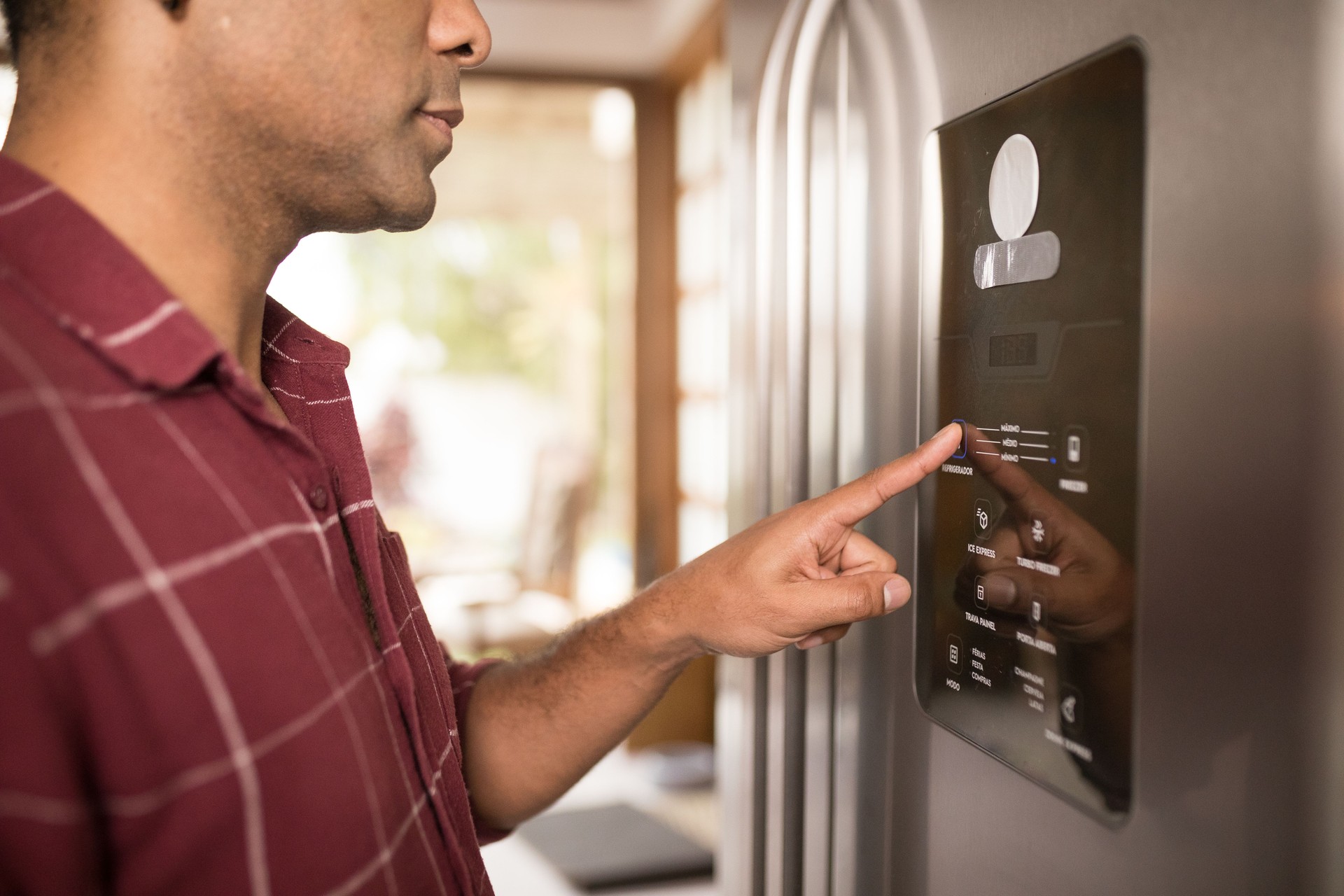 Man using the fridge's digital panel to cool groceries faster